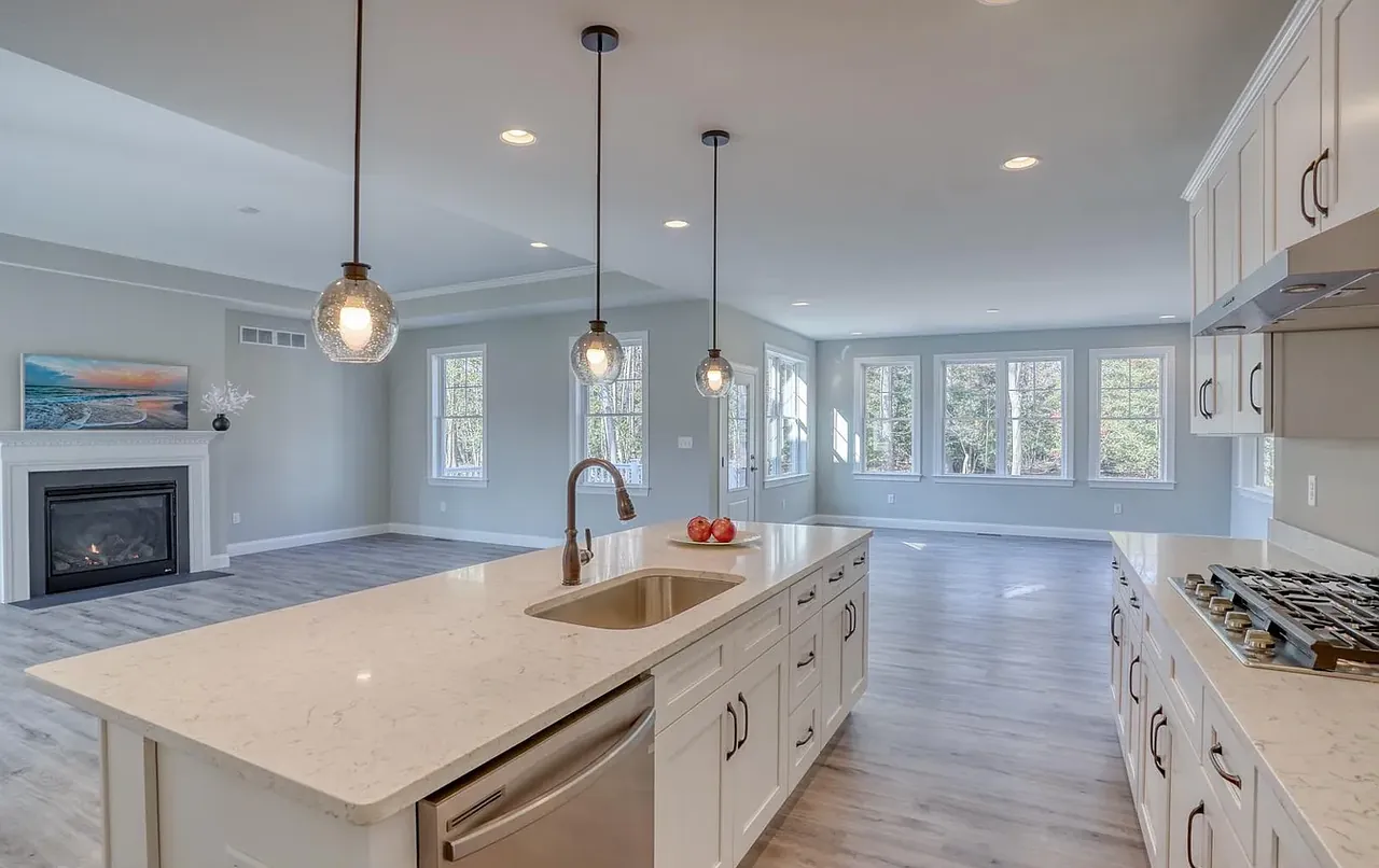 Open kitchen with quartz island, pendant lighting and a wall of windows