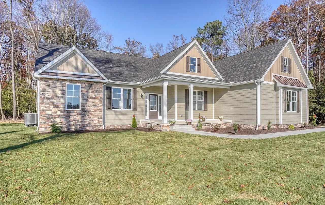 Angled view of a craftsman new build with stone detailing and mature treeline